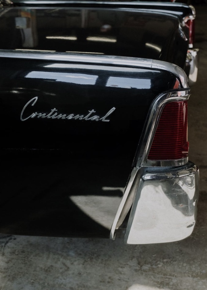 Vintage black, Lincoln Continental parked in a garage.
