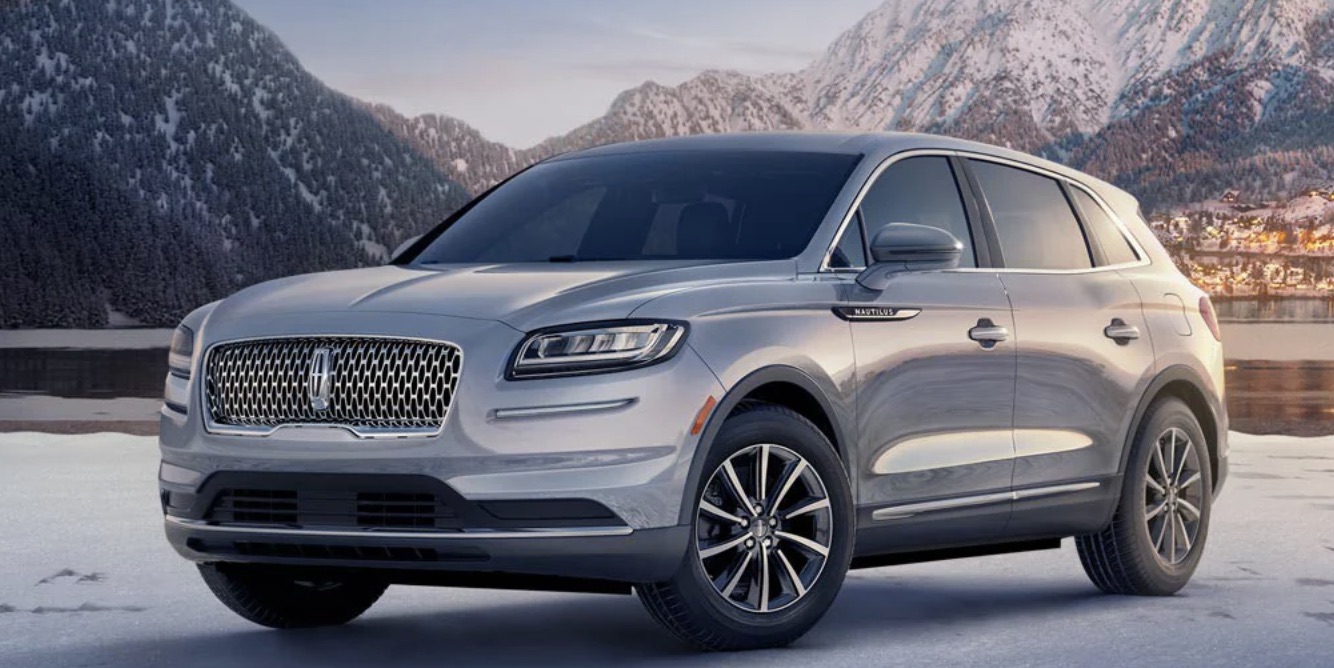 2022 Lincoln Nautilus parked on a sheet of ice surrounded by mountains in the snow.