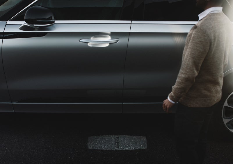 A person approaches a 2023 Lincoln Aviator® Grand Touring as the Lincoln Embrace sequence of welcome lighting illuminates | Lexington Park Ford Lincoln in California MD