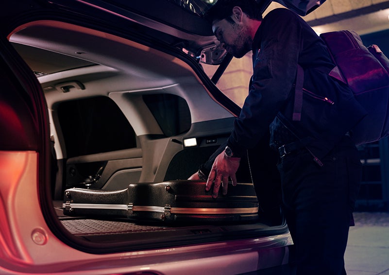 A man is shown loading cargo into the rear of a 2024 Lincoln Corsair® SUV with the second-row seats folded flat. | Lexington Park Ford Lincoln in California MD