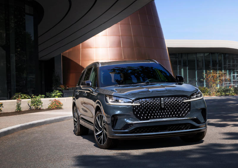 A gray 2025 Lincoln Aviator® SUV is parked outside a modern building with the sun shining. | Lexington Park Ford Lincoln in California MD