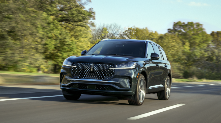 A 2025 Lincoln Black Label Aviator® SUV is being driven down a road lined with trees. | Lexington Park Ford Lincoln in California MD