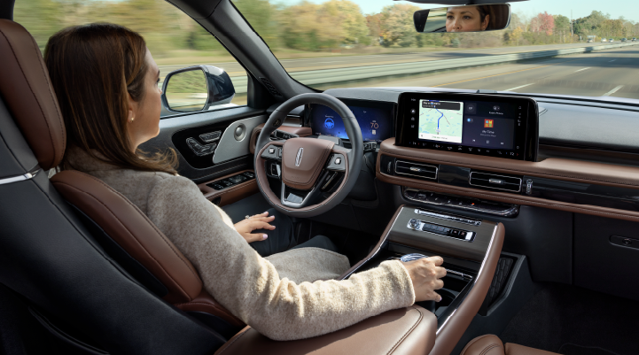 A woman is seen sitting in the driver’s seat of her 2025 Lincoln Aviator® SUV with her hands off the steering wheel. | Lexington Park Ford Lincoln in California MD