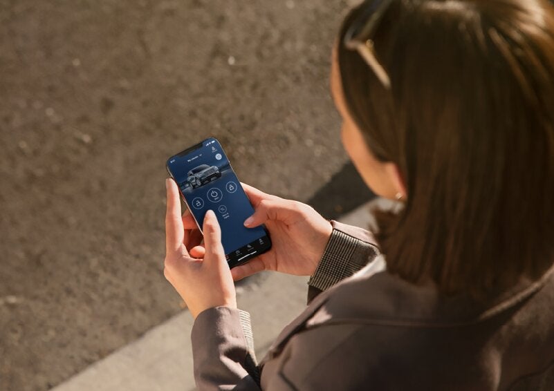 A person is shown interacting with a smartphone to connect to a Lincoln vehicle via the Lincoln Way® App. | Lexington Park Ford Lincoln in California MD