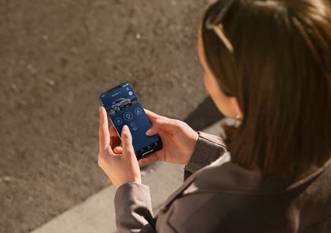 A person is shown interacting with a smartphone to connect to a Lincoln vehicle via the Lincoln Way® App. | Lexington Park Ford Lincoln in California MD