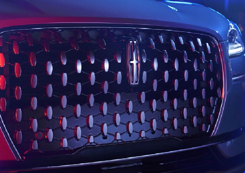 The grille of a 2025 Lincoln Corsair® SUV reflects neon light at night. | Lexington Park Ford Lincoln in California MD