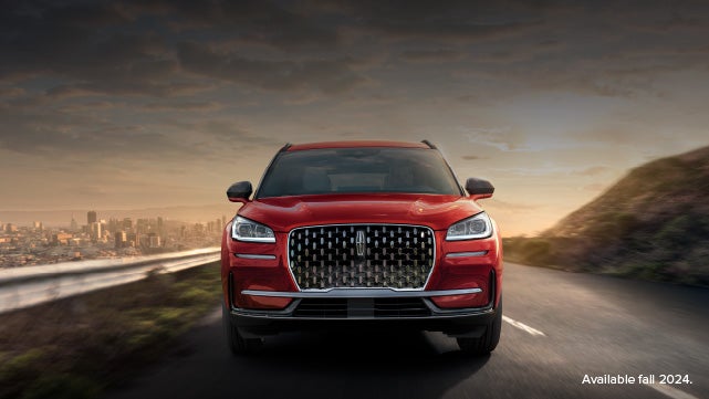 A 2025 red Lincoln Corsair® SUV is being driven down a road at sunset. | Lexington Park Ford Lincoln in California MD