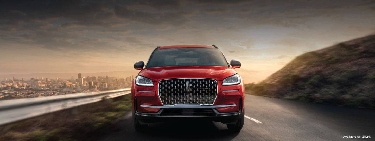 A 2025 red Lincoln Corsair® SUV is being driven down a road at sunset. | Lexington Park Ford Lincoln in California MD