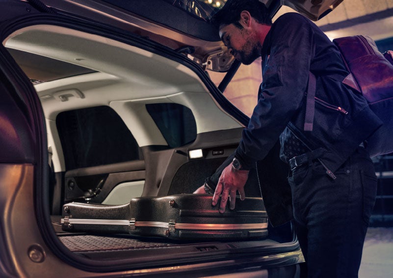 A man is shown loading cargo into the rear of a 2024 Lincoln Corsair® SUV with the second-row seats folded flat. | Lexington Park Ford Lincoln in California MD
