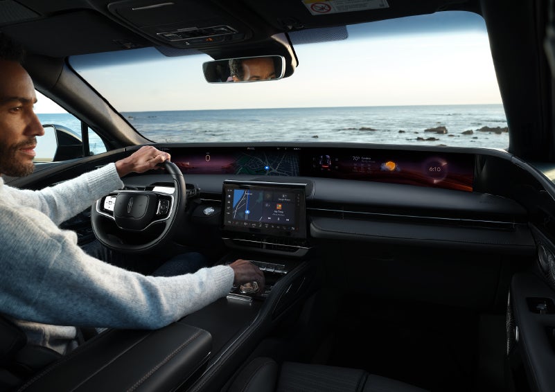 A driver of a parked 2025 Lincoln Nautilus® SUV takes a relaxing moment at a seaside overlook while inside his Nautilus. | Lexington Park Ford Lincoln in California MD