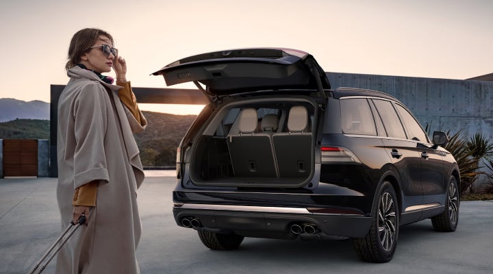 A woman approaches a 2026 Lincoln Aviator® SUV with its rear liftgate open. | Lexington Park Ford Lincoln in California MD