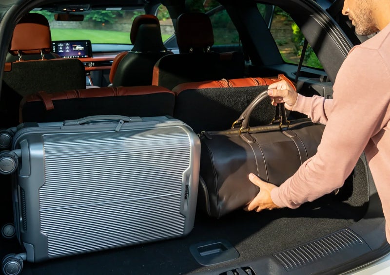 A man loads luggage into the rear of a 2026 Lincoln Aviator® SUV through the opened rear liftgate. | Lexington Park Ford Lincoln in California MD