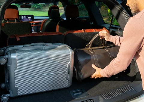 A man loads luggage into the rear of a 2026 Lincoln Aviator® SUV through the opened rear liftgate. | Lexington Park Ford Lincoln in California MD