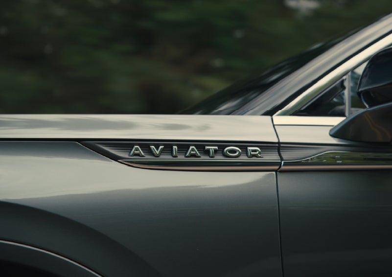 The driver’s side door and fender badging of a gray 2027 Lincoln Aviator® SUV are showcased. | Lexington Park Lincoln in California MD